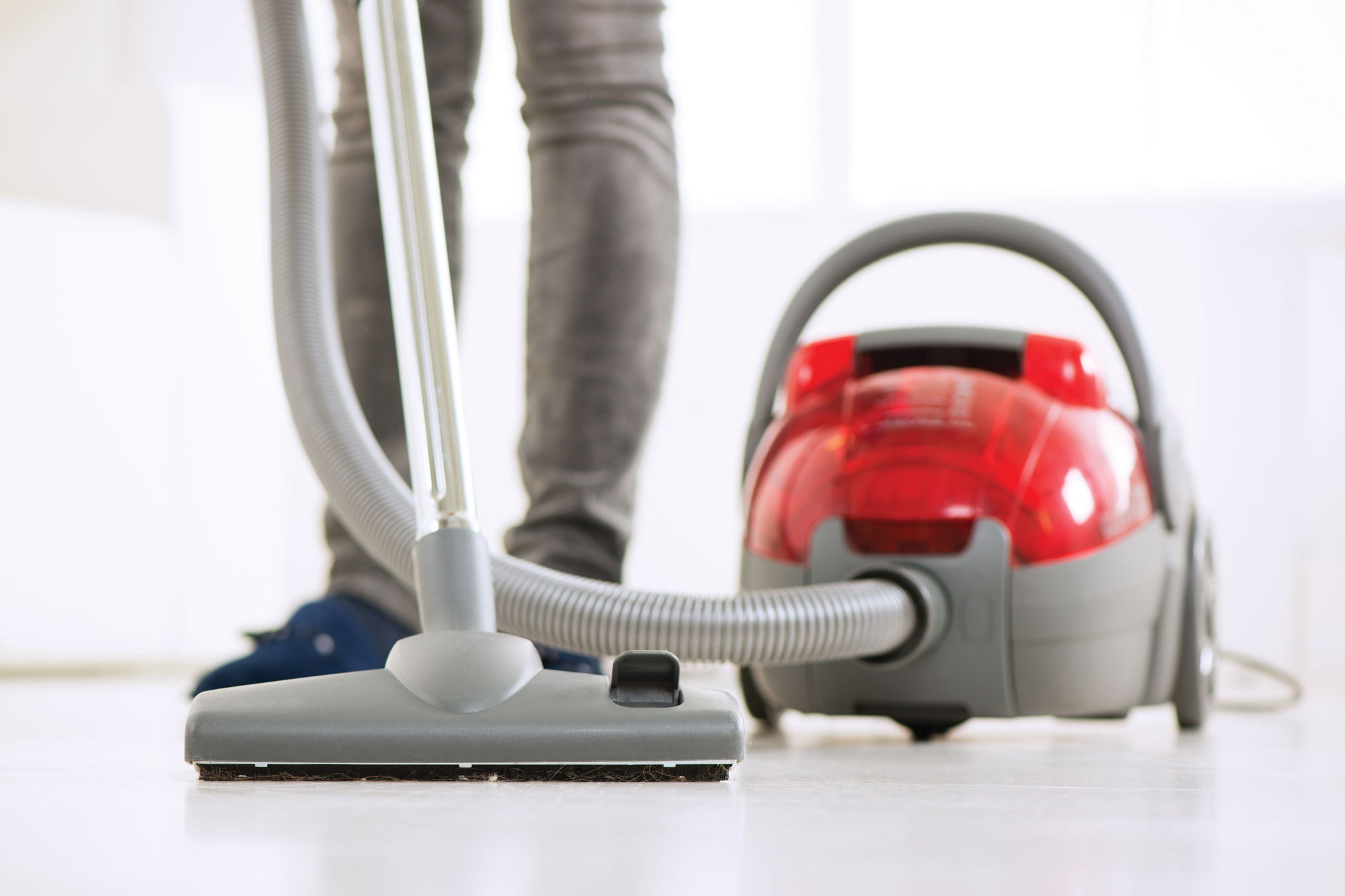 a person using a red vacuum
