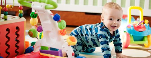 baby crawling on floor, surrounded by toys