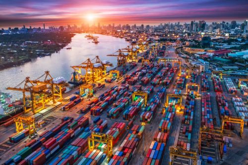 The image is of a shipping yard at sunset